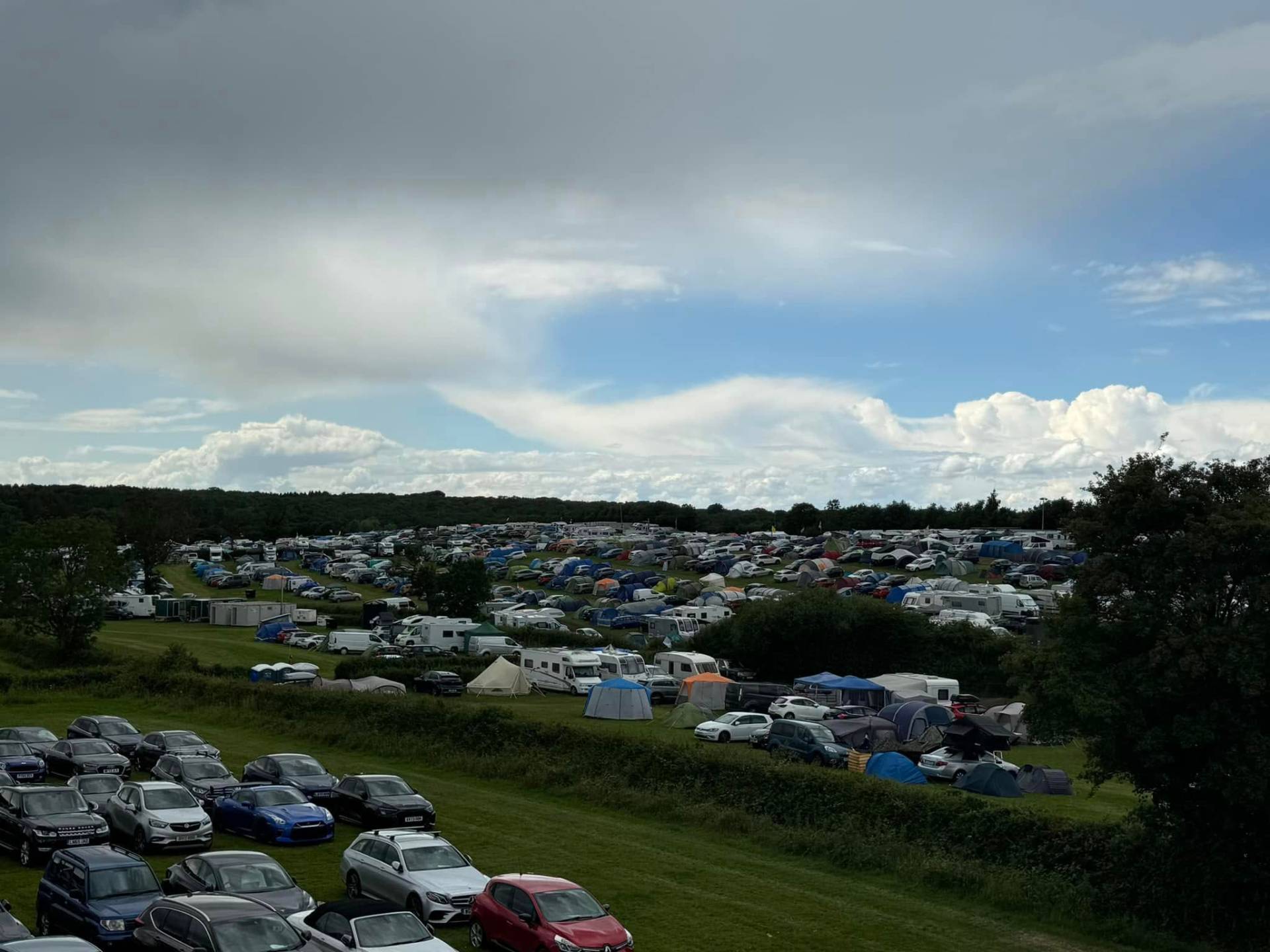 Panoramic view of the camping grounds with tents spread across green fields