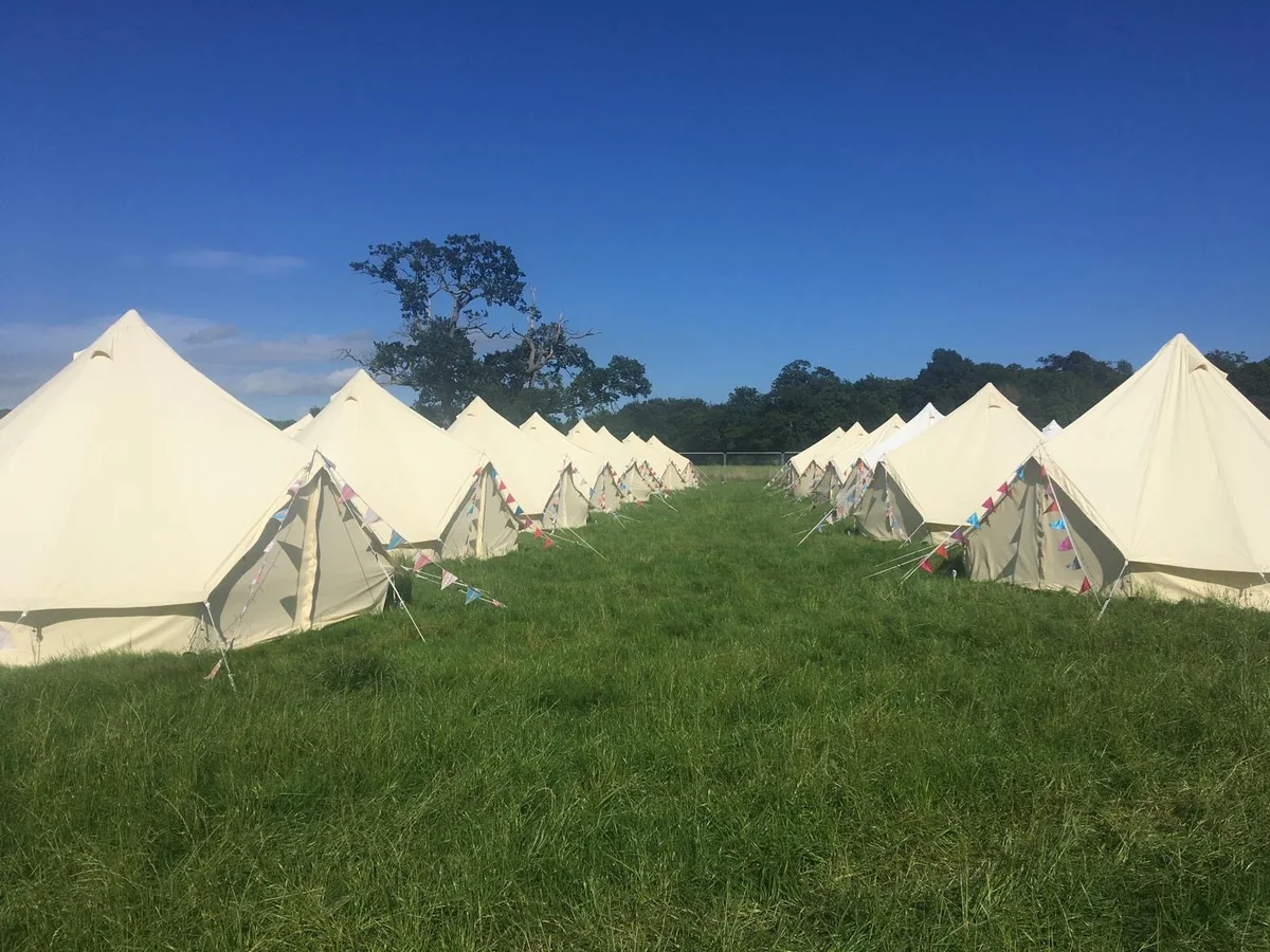 Glamping village with rows of bell tents and colourful bunting