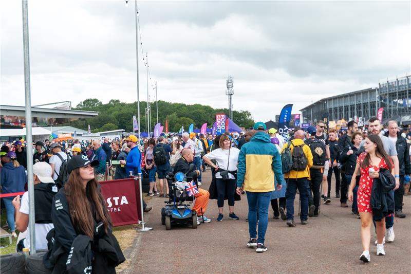 Diverse crowd walking through Silverstone circuit grounds including wheelchair access