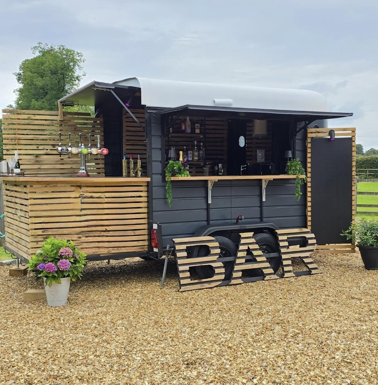 Converted horsebox mobile bar serving drinks to campers