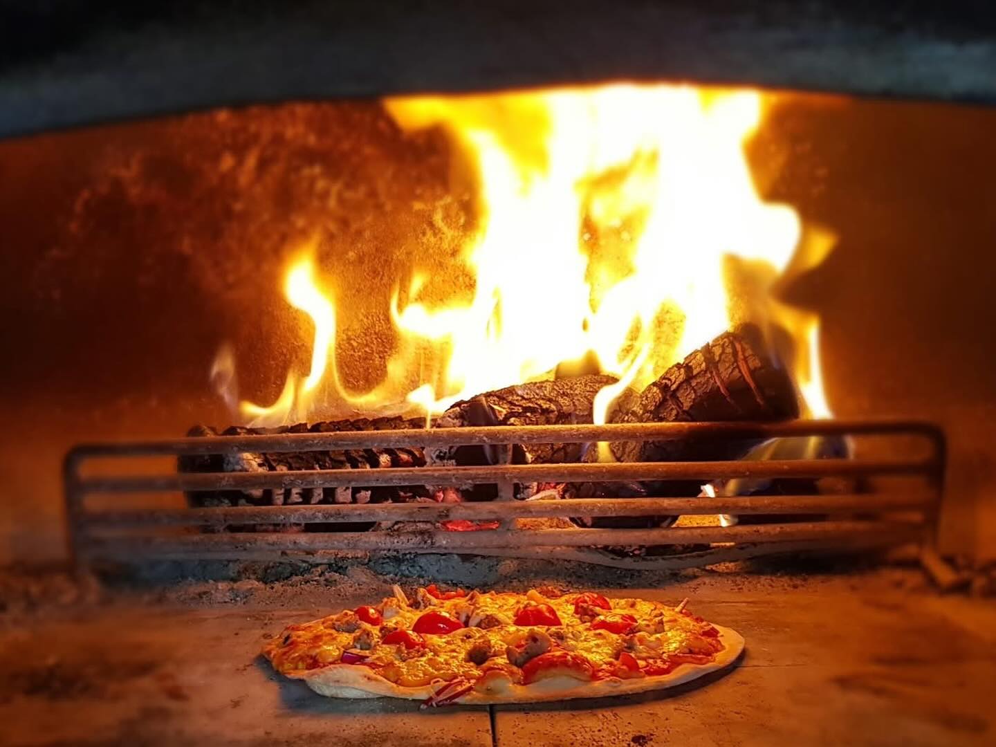 Wood-fired pizza oven cooking authentic Italian pizzas