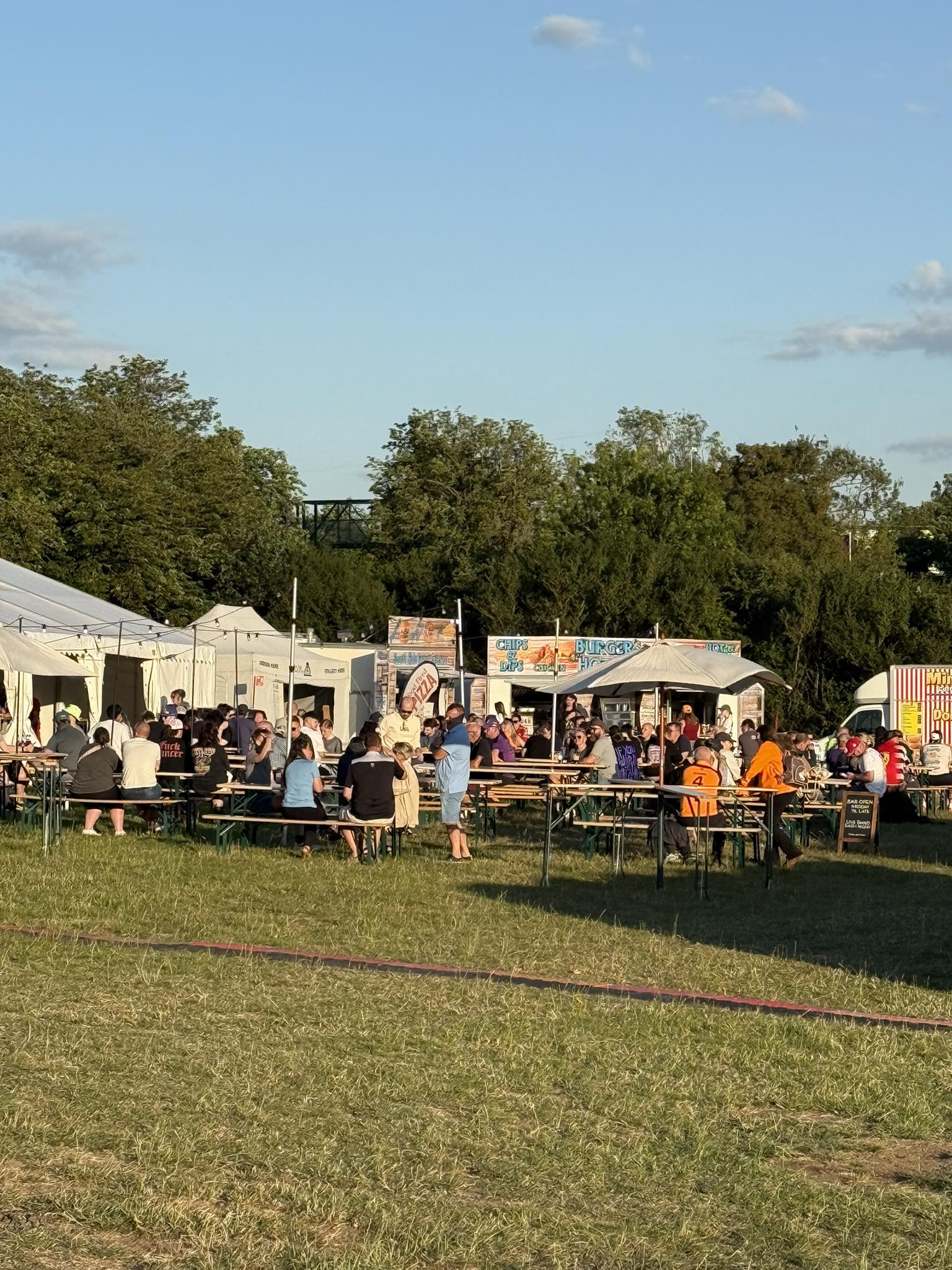 Food court area during daytime with campers enjoying meals at outdoor tables